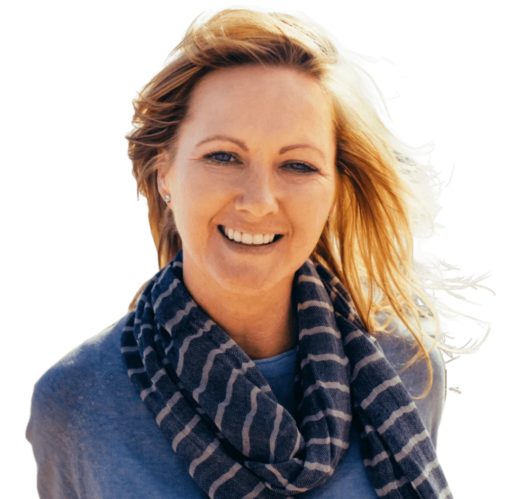 A woman with blonde hair wearing a blue sweater and scarf.