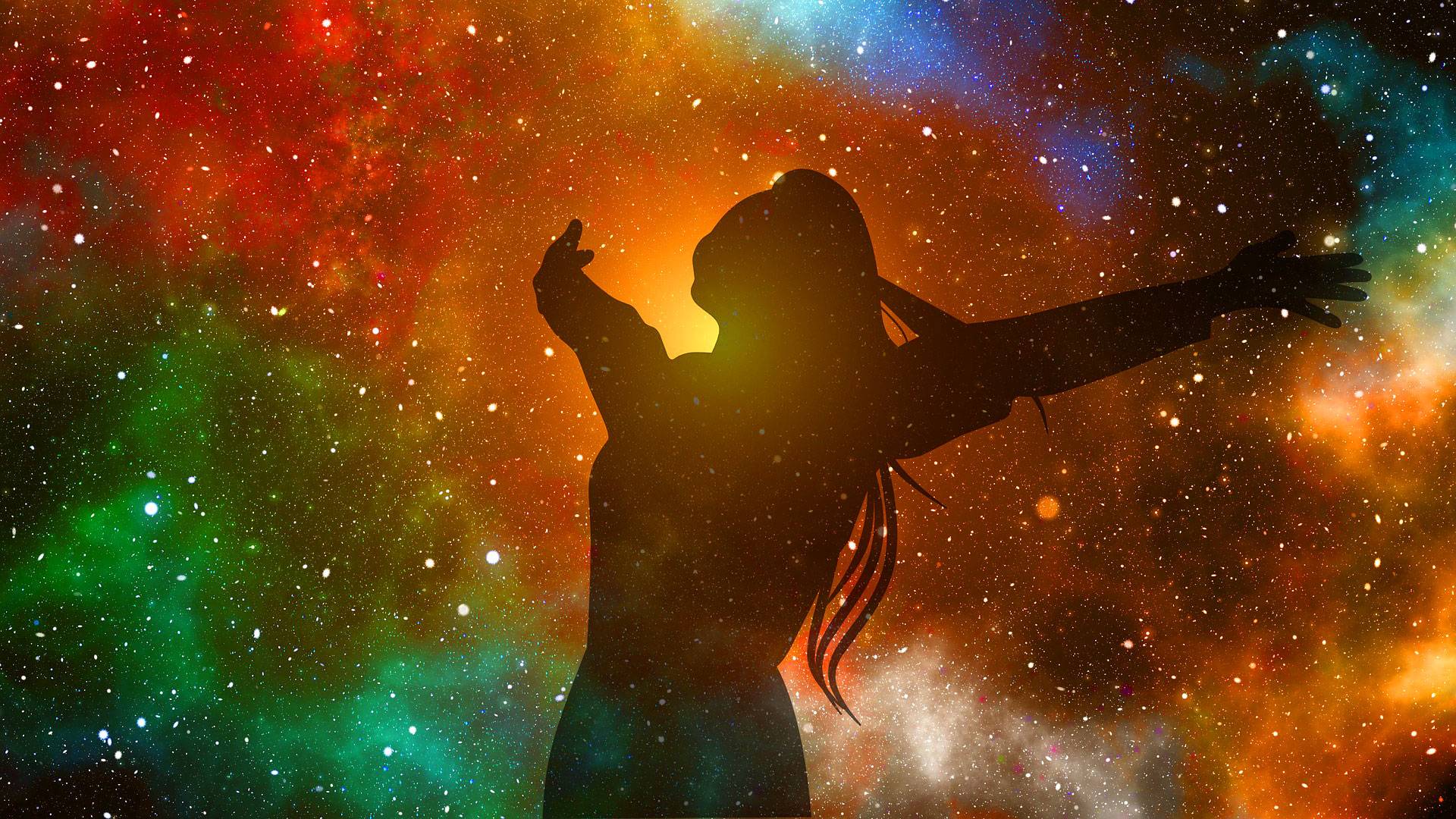 A woman standing in front of the universe with her arms outstretched.