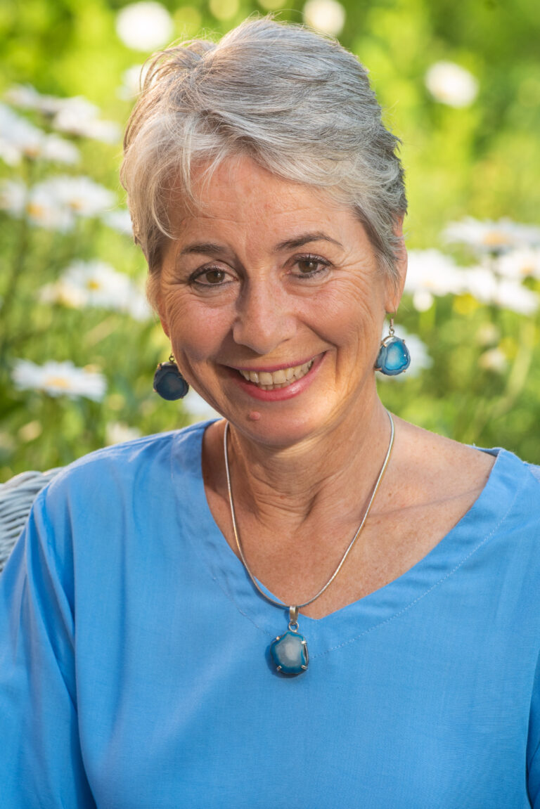 A woman wearing blue is smiling for the camera.